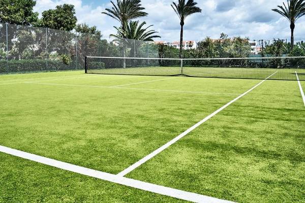 Tennisplatz im Falesia Hotel - Algarve mit grünem Kunstrasen und weißem Rand.