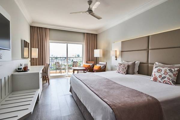 Schlafzimmer im Falesia Hotel - Algarve mit einem großen Bett, einem Balkon und modernen Möbeln.