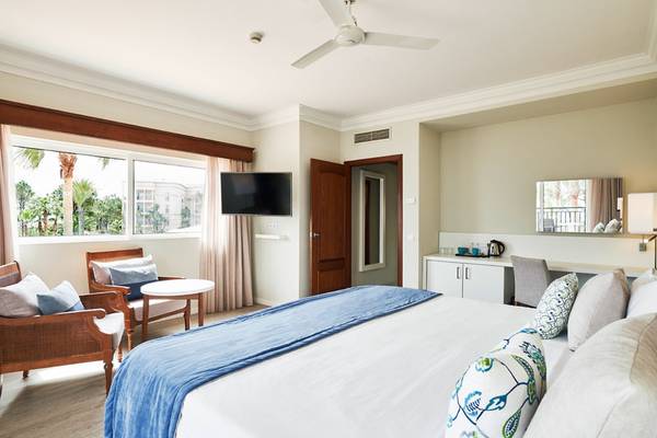 Innenansicht eines Zimmers im Falesia Hotel - Algarve mit Bett, Fernseher und Fenster.