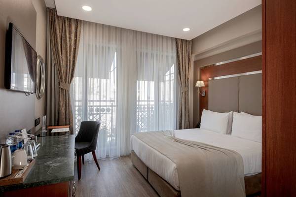 Ein elegantes Hotelzimmer mit einem Bett, Schreibtisch, Stuhl und Fernseher.