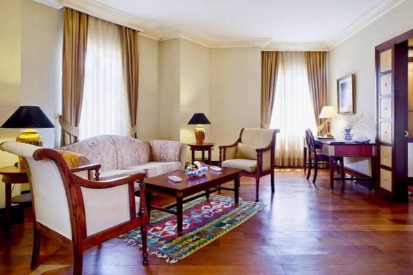 Wohnzimmer des Eresin Sultanahmet Hotels mit Sofa, Stühlen, Tisch und Teppich.