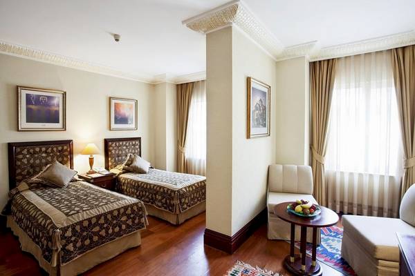 Doppelzimmer im Eresin Sultanahmet Hotel mit zwei Betten, Lampe, Nachttisch und Fenstern.