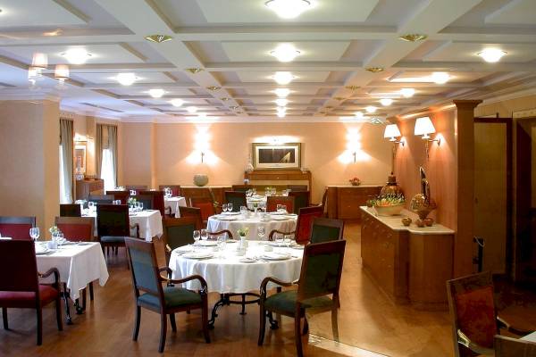 Innenansicht des Eresin Sultanahmet Hotels Restaurant mit runden Tischen, Stühlen und beleuchteten Decken.