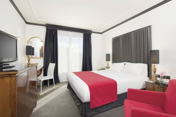 Ein modernes Hotelzimmer der Villa Marquis Melia Collection mit einem Doppelbett, einem Fernseher und einem Schreibtisch.