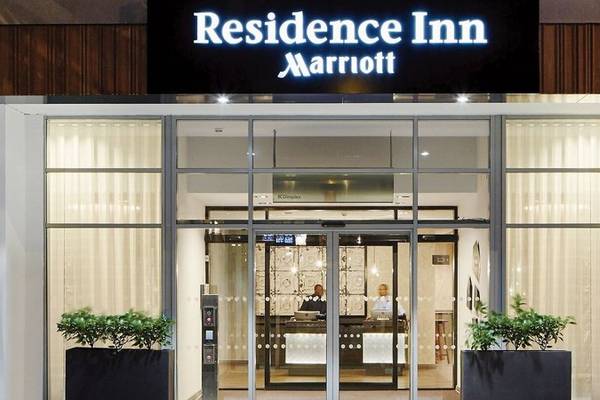 Eingang des Residence Inn by Marriott London Bridge mit Schild und zwei Mitarbeitern im Innenbereich.