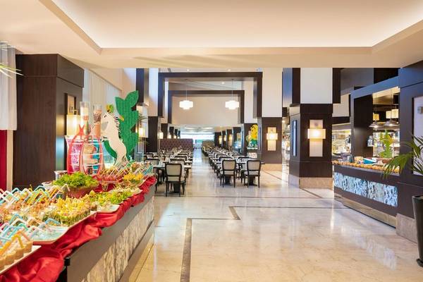 Innenbereich des Kaya Belek Hotels mit einem langen Buffet und gedeckten Tischen.