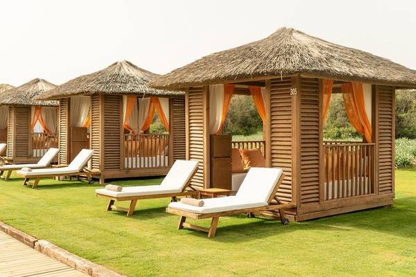 Reihe von holzverkleideten Hütten mit Liegen auf dem Rasen, Rixos Premium Belek