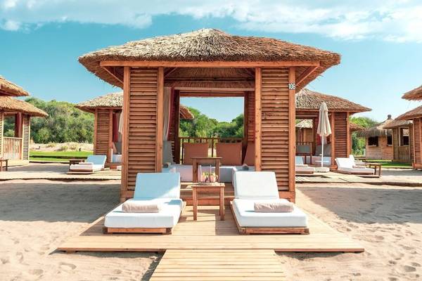 Luxuriöse Strandhütten im Rixos Premium Belek Hotel mit Blick auf eine blaue Himmel