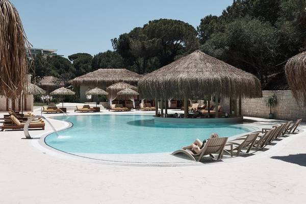 Poolbereich im Rixos Premium Belek mit Sonnenliegen und Bar