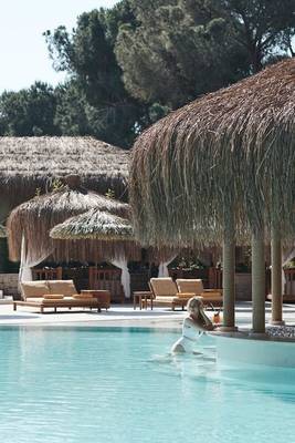 Ein Pool-Loungebereich mit einer Frau am Rixos Premium Belek.