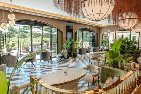 Innenbereich des Rixos Premium Belek Hotels mit modernem Design, großen Pflanzen und eleganten Möbeln.