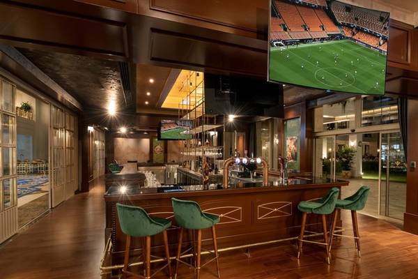 Innenansicht der Bar im Rixos Premium Belek Hotel mit grünen Stühlen und Fernseher
