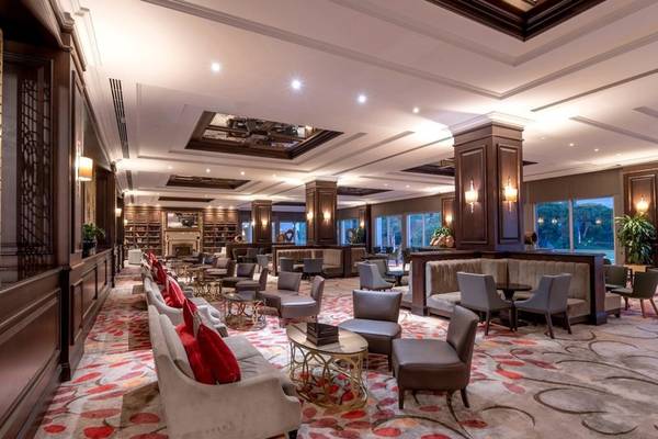 Lobby des Rixos Premium Belek Hotels mit gemustertem Teppich, Sofas und Tischen.