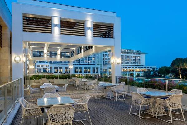 Terrasse des Rixos Premium Belek Hotels mit Tischen und Stühlen bei Nacht