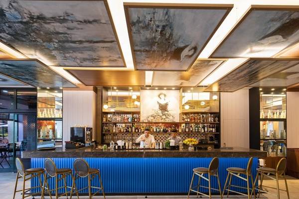 Innenansicht der Bar im Rixos Premium Belek Hotel mit Barkeepern und Kunden.
