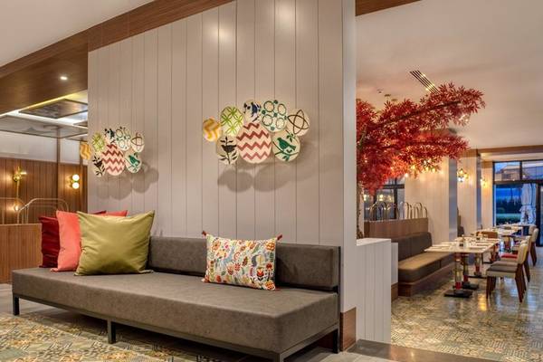 Lobby-Bereich des Rixos Premium Belek Hotels mit bunten Kissen und Tisch.