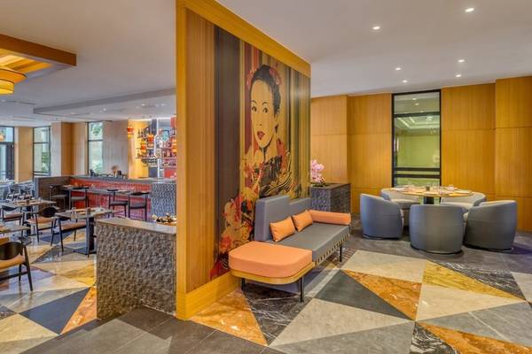 Innenbereich des Rixos Premium Belek Hotels mit moderner Einrichtung, gemustertem Boden und einer großen Wandkunst.
