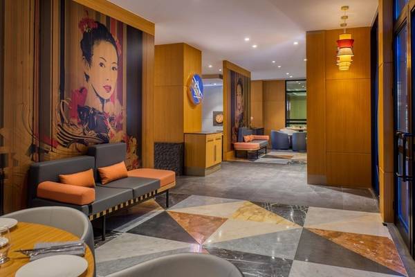 Rixos Premium Belek Hotel Innenbereich mit gemustertem Boden, Couch und Wandkunst.