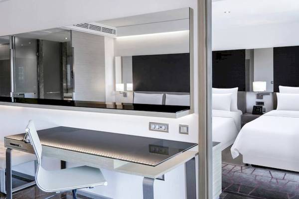 Innenansicht eines Gästezimmers im Rixos Premium Belek Hotel mit Schreibtisch und Bett.