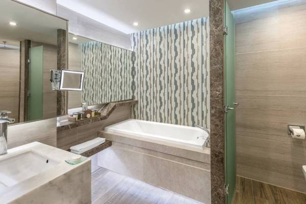 Badezimmer im Rixos Premium Belek mit Badewanne, Spiegel und Marmorwänden