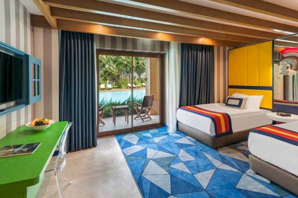 Zimmer im Rixos Premium Belek mit zwei Betten, Balkon und Swimmingpool-Blick.