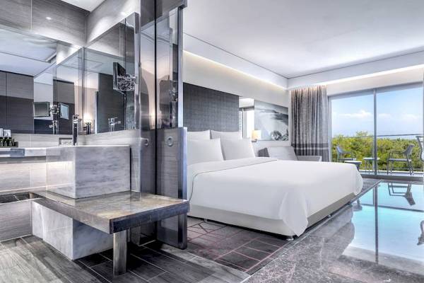 Suite-Schlafzimmer im Rixos Premium Belek mit großem Bett, Marmorboden und Aussicht auf Außenterrasse.