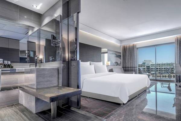 Innenansicht eines Hotelzimmers im Rixos Premium Belek, mit modernem Design, großem Bett und Badezimmerbereich.