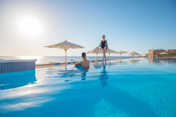 Schwimmbad des Pickalbatros Citadel Resorts mit Sonnenschirmen und Meerblick
