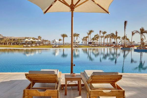 Pool-Lounge-Bereich im Steigenberger Resort Alaya mit zwei Holzliegen und einem Schirm