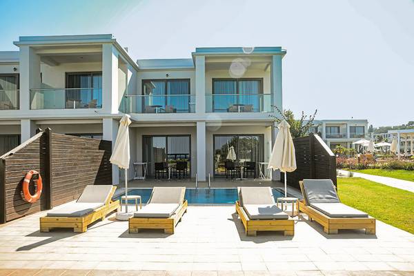 Lounge-Bereich des Asterias Beach Resort mit Swimmingpool und Sonnenliegen