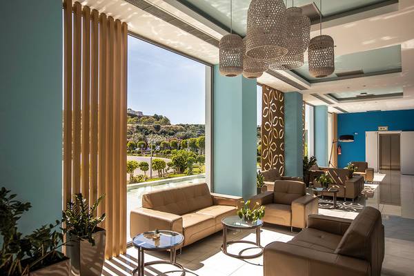Empfangsbereich des Asterias Beach Resorts mit Sofas, Tischen und Pflanzen.