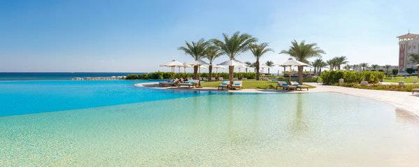 Außenpool des Baron Palace Sahl Hasheesh Hotels mit Sonnenliegen und Palmen