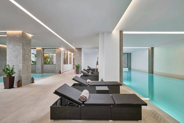 Innenpool mit Loungeliegen im Lindos Grand Resort & Spa.