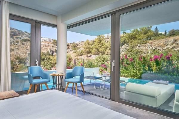 Zimmer im Lindos Grand Resort & Spa mit Terrasse und Poolblick.