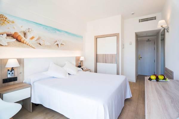 Innenansicht eines Zimmers im THB Gran Playa Hotel mit einem großen Bett und einer Wanddekoration mit Muscheln und Sternen.