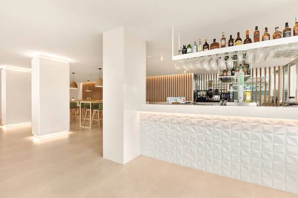 Innenansicht der Rezeption des THB Gran Playa Hotels mit geometrischen Wandverkleidungen und hellem Interieur.