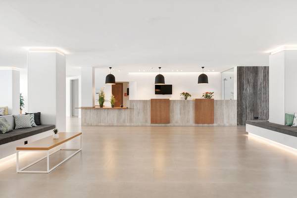 Innenansicht der Lobby des THB Gran Playa Hotel mit hellen Wänden, Betonboden und Beleuchtung.