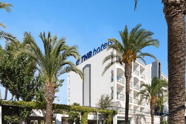 Außenansicht des THB Gran Playa Hotels mit weißen Gebäuden und Palmen im Vordergrund.