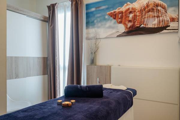 Massagebereich im THB Gran Playa Hotel mit Liege, Kerzen und Strandmotiv