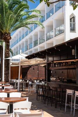 Außenterrasse des THB Gran Playa Hotels mit Tischen, Stühlen und Palme
