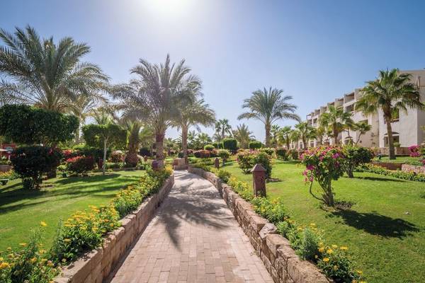 Gartenweg im Fort Arabesque Resort, Spa & Villas mit Palmen und Blumen.