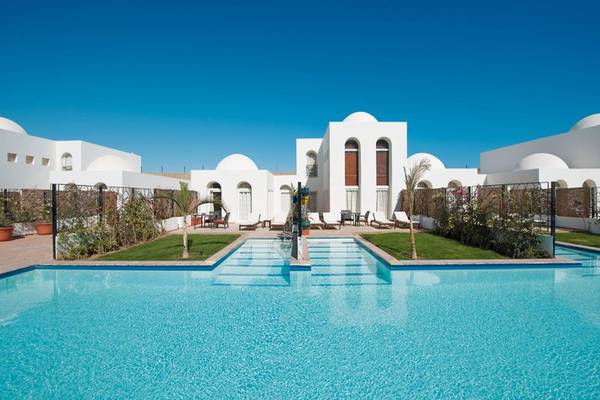 Außenpool des Fort Arabesque Resort mit weißen Gebäuden und Sonnenliegen