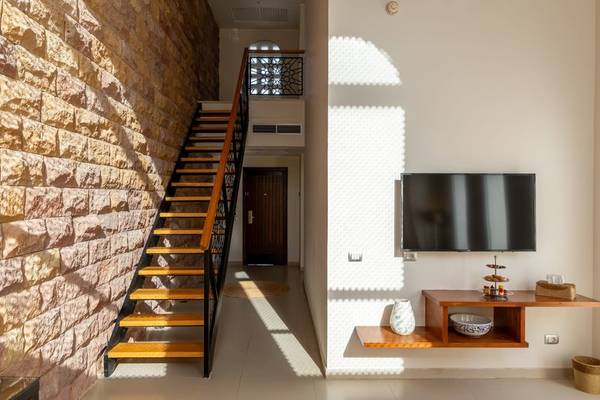 Innenansicht des Fort Arabesque Resorts mit einer Treppe und einem Fernseher an der Wand.