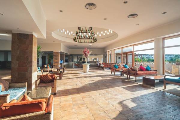 Innenbereich des Fort Arabesque Resorts mit Lounge-Bereich, Kronleuchter und großen Fenstern.
