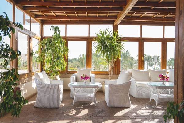 Loungebereich im Fort Arabesque Resort mit weißen Möbeln und großen Fenstern.