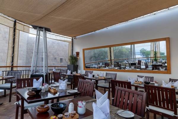 Innenbereich des Restaurants im Fort Arabesque Resort, Spa & Villas mit gedeckten Tischen und Stühlen.