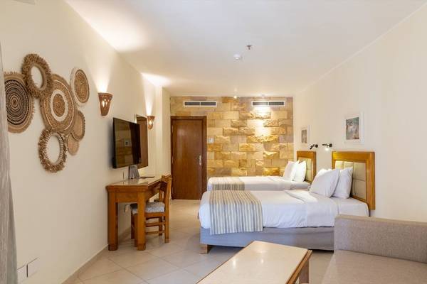 Schlafzimmer im Fort Arabesque Resort mit zwei Betten, Schreibtisch und Couch.