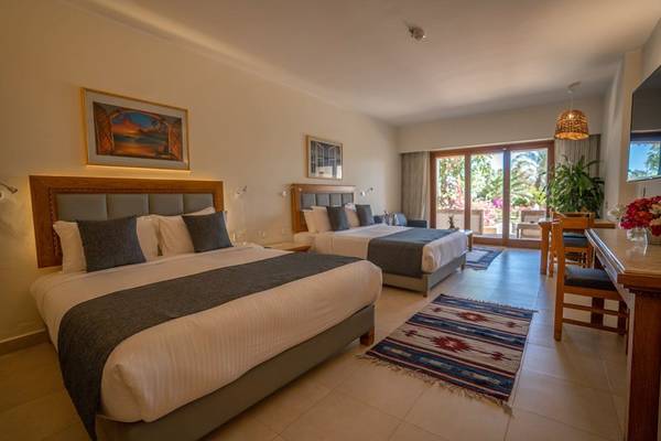 Schlafzimmer im Fort Arabesque Resort mit zwei Doppelbetten und einem Wohnzimmerbereich.