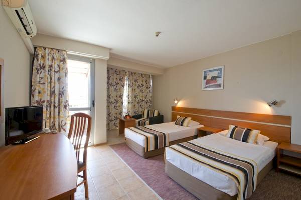 Doppelzimmer im Excelsior Hotel mit zwei Betten, Fernseher, Schreibtisch und Stuhl.