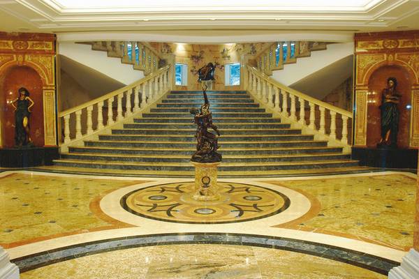 Lobby des Palm Royale Soma Bay Hotels mit einem zentralen Brunnen und zwei Statuen an den Seiten.